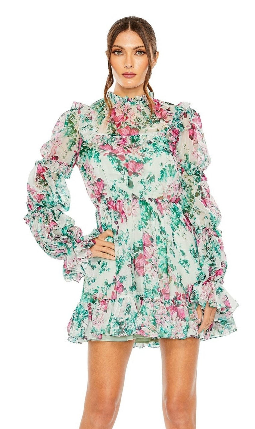 A woman stands against a white background wearing the Mac Duggal High-Neck Print Party Dress 56008, featuring long sleeves, puffed shoulders, a floral print, ruffled mini skirt, and high neckline.